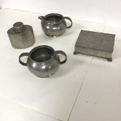 A Liberty Tudric pewter milk jug and sugar bowl and a Tudric tea cannister, all with a beaten