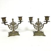 A pair brass candelabrum, each with two arms holding a candleholder with a central cartouche