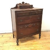 An early 20thc French walnut chest of drawers, the arched back incorporating a drawer above a