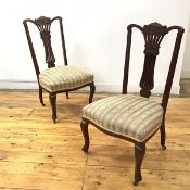 A pair of Edwardian mahogany parlour chairs, each yoke shaped top rail with carved scroll tablet