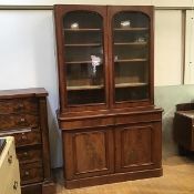 A Victorian mahogany cabinet bookcase, the pair of arched glazed doors enclosing four adjustable