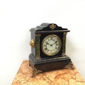 A late 19thc. ebonised and gilt metal mounted mantel clock, the circular roman dial within fluted