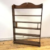 A set of freestanding oak open shelves, early 20thc., the undulating top with applied lozenge