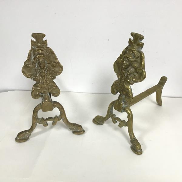 A pair of Edwardian cast brass fire dogs with cast brass mask terminals (h.30cm)