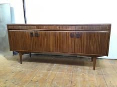 A 1960s simulated macassar ebony sideboard, the rectangular top with moulded edge above three frieze
