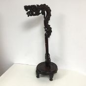 A 1900s Chinese cherrywood gong stand, the gong holder in the form of a dragon, on a turned stem