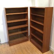 A pair of 1960s teak open bookcases, each of rectangular form, the stepped top above three open