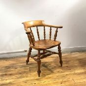 A stained ash smoker's chair, c.1900, the hoop shaped back supported by turned spindles, above a