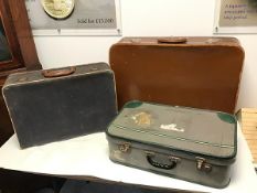 A set of three vintage travel cases, including one of brown treated leather, blue canvas and green
