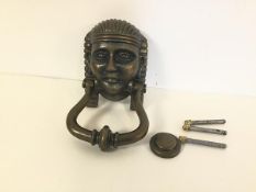 A patinated iron door knocker in the form of an Egyptian Pharoah (h.17cm x 9cm)
