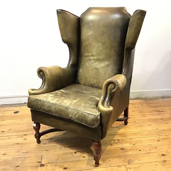 A handsome moss green leather upholstered wing armchair by Wade Upholstery, Long Eaton, the padded