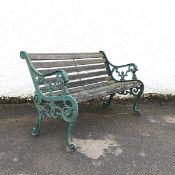 A modern green painted cast iron bench, the pierced ends incorporating lion mask terminals, raised