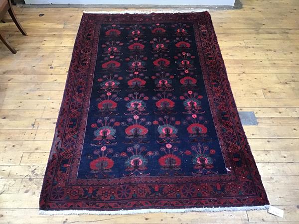 A North West Persian peacock rug, the indigo field with rows of stylised birds within madder and