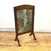 A 1940s mahogany framed firescreen, the arched top enclosing a grospoint tapestry banner depicting a