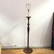 A wooden floor lamp, the fluted baluster stem incorporating a foliate knop raised on a gadrooned