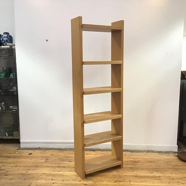 A modern freestanding light oak bookshelf, the rectangular upright supporting six adjustable shelves