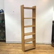 A modern freestanding light oak bookshelf, the rectangular upright supporting six adjustable shelves