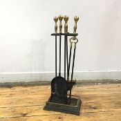 A blackened steel and brass companion stand, supported a matching set of log turner, shovel, tongs