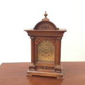 A German quarter chiming Ting-Tang mantel clock, the arched brass dial with arabic numerals,