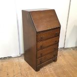 A 1920s small bureau, the rectangular fall front enclosing pigeonholes and a writing surface,