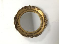 A circular dressing table mirror, the circular plate within a gilt composition frame with moulded