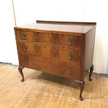 A 1920s walnut chest, the rectangular top with shallow gallery above three long drawers, raised on