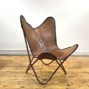 A butterfly chair, after the 1930s design, the stitched hide seat with perforated edge supported