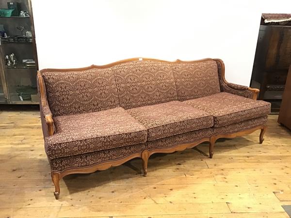 A modern French sofa, the moulded fruitwood frame enclosing a padded back and three cushion seat,