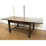 A large oak draw leaf dining table, c.1920s, the rectangular top with pull out leaves, raised on