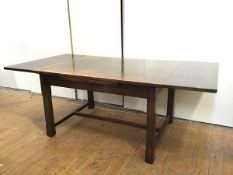 A large oak draw leaf dining table, c.1920s, the rectangular top with pull out leaves, raised on