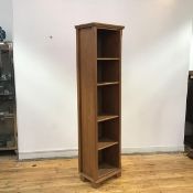 A modern oak bookcase, the rectangular frame enclosing four adjustable shelves, raised on square