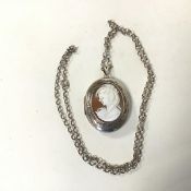 An early 20thc silver locket of oval form with a carved shell cameo to front (4cm x 5cm) on a silver