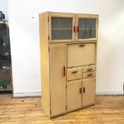 A 1930s pantry cupboard, yellow painted with red handles, the square frame with a pair of glazed