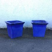 A pair of large garden planters of square tapered form with moulded edges in varying hues of lapis