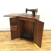 A 1940s Singer sewing machine, the treadle device with gold painted highlights, contained within a