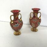 A pair of Bohemian cranberry glass bud vases, c.1900, of amphora form with flared rims, with gilt