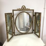 A triptych dressing table mirror, the central oval mirror hinged to a square frame, with a ribbon
