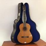 An accoustic guitar by Yamaha the label inscribed Nippon Garri Co. Ltd of typical gourd shaped form,
