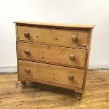 A Victorian stripped pine chest, the moulded rectangular top above three long drawers, raised on