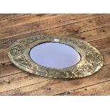 A Glasgow School style Arts & Crafts oval wall mirror, the brass frame embossed with Celtic motifs