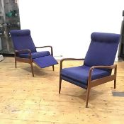 A pair of 1960s teak framed reclining lounge chairs, the padded buttoned back with original blue