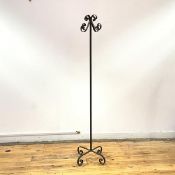 A wrought iron coat stand, the tubular shaft with scrolling hooks and complementary feet (161cm x