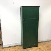 An Edwardian green painted balsa wood cabinet, the projecting cornice above a panelled door with