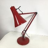 A modern red painted anglepoise lamp with circular base and conical shade (height max: 81cm)