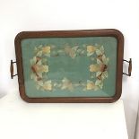 A 1920s/30s tea tray, the moulded border enclosing an embroidered panel depicting butterflies, fruit