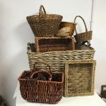 An assortment of wicker ware baskets including a large laundry basket with canvas lining and