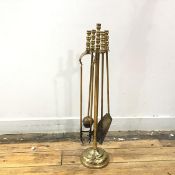 A brass companion stand supporting a shovel, a pair of tongs and brush on spreading circular base