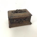 An early 20thc jewellery box, the hinged top with raised carving of flowerheads and leaves, the