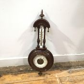 An Edwardian walnut cased barometer, the arched top above a fahrenheit scale, with barometer dial