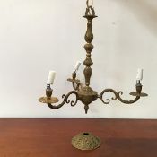 A gilt brass three branch ceiling pendant, the baluster shaped stem decorated with foliate motifs